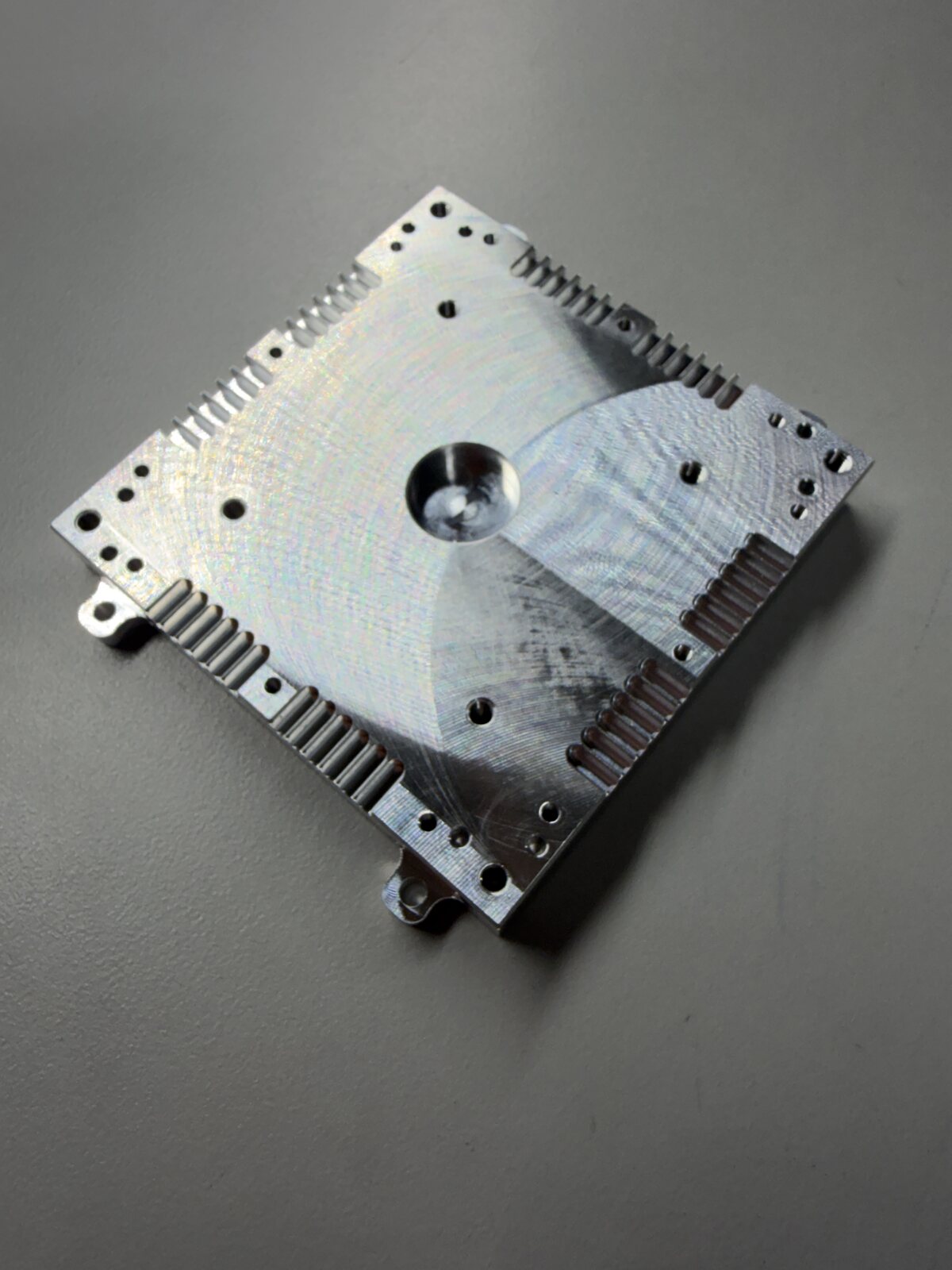 Machined aluminum plate with perimeter cooling fins and precision bores