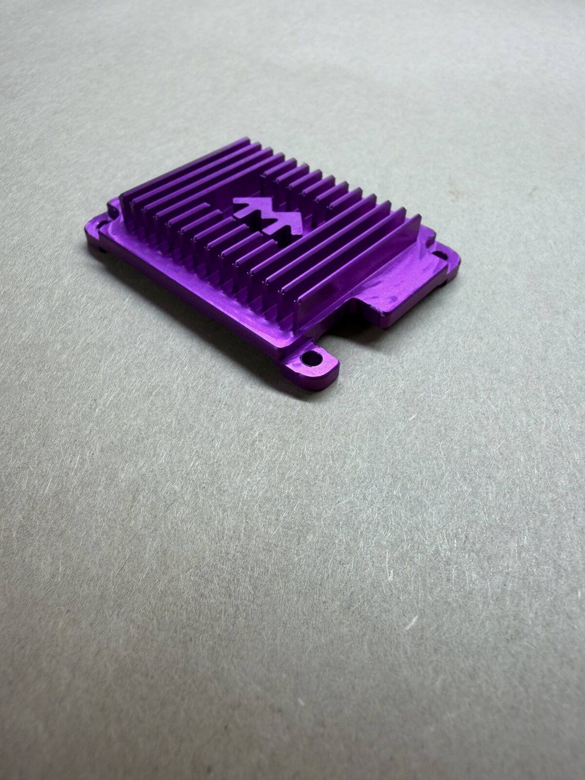 Angled view of a purple anodized finned aluminum part